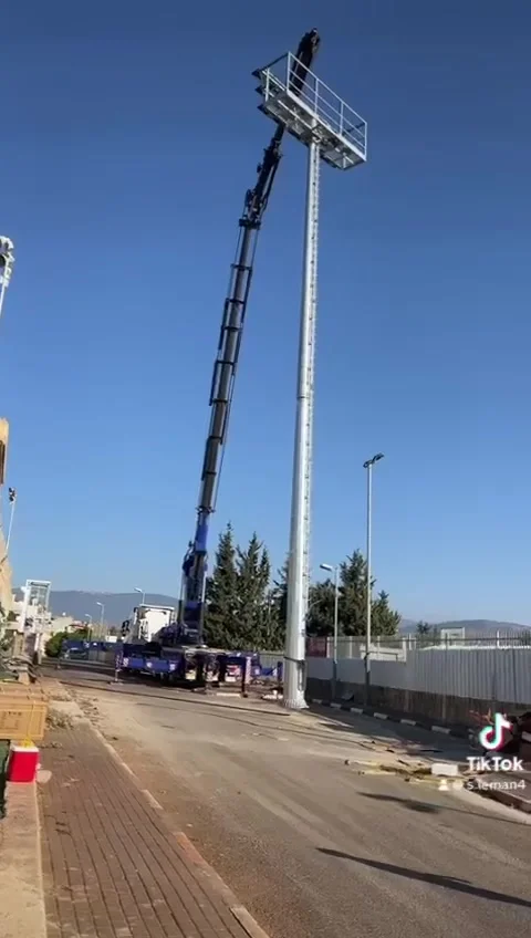 עבודה בגובה על תורן תאורה במגרש ספורט באמצעות מנוף